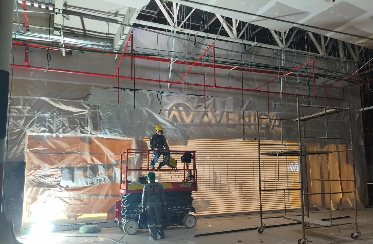 Equipe trabalhando em plataforma elevatória na fachada de loja